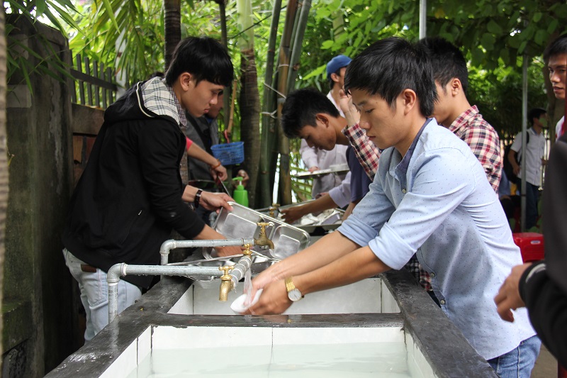Các bạn trẻ rửa khay sau bữa ăn tại Quán Cơm Xã Hội